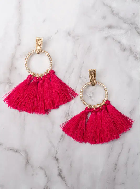 Pink tassel earrings on a marble surface