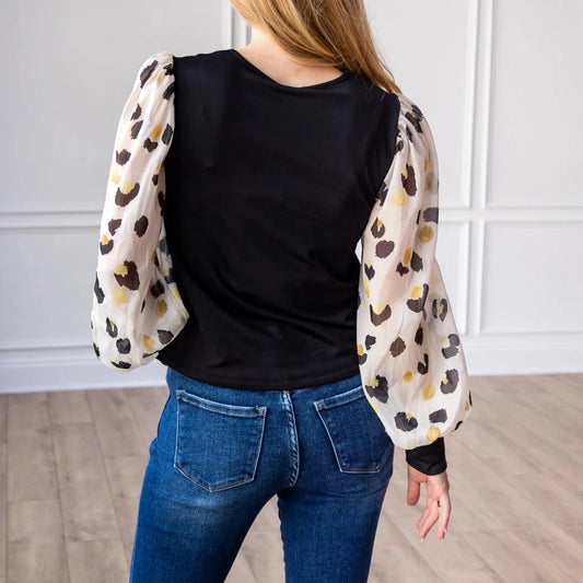 Leopard Sleeve Top is a stylish blend of simplicity and boldness. Featuring sheer leopard-print puff sleeves and a sleek solid bodice.