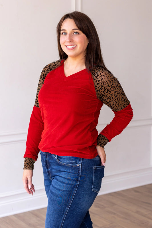  Red Velvet Top is a bold and stylish choice for any wardrobe. Featuring a luxurious red velvet body paired with leopard print accents on the sleeves and cuffs.