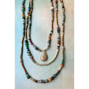 Stack of beaded necklaces on a light background