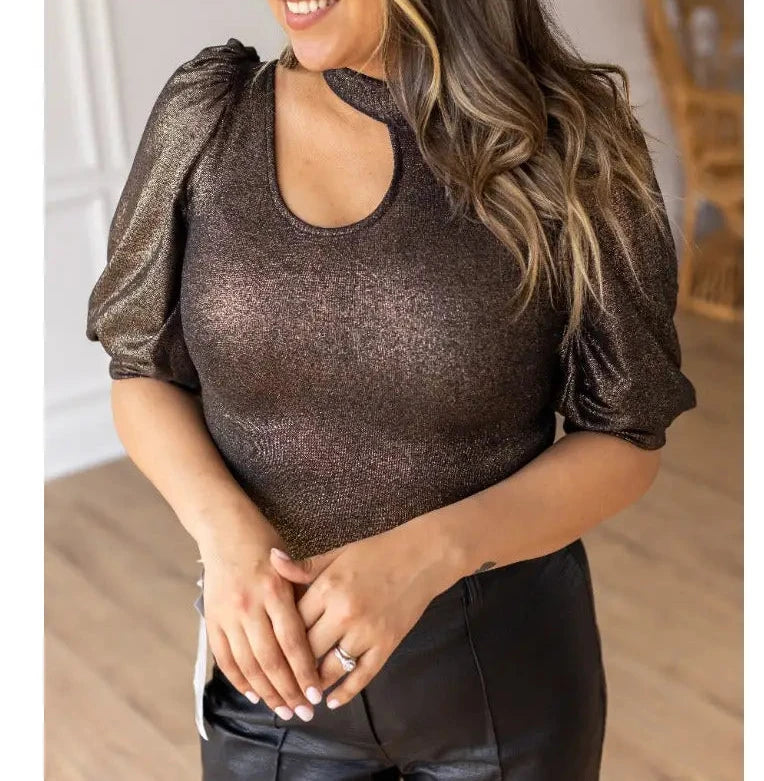  Metallic Puff Sleeve Bodysuit is a statement piece that brings elegance and glamour to any outfit. Featuring a shimmering metallic finish, puff sleeves, and a chic keyhole neckline.