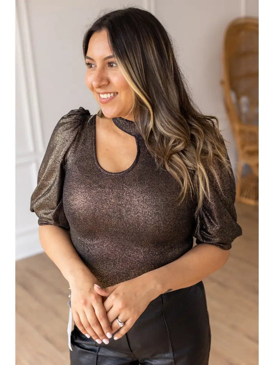  Metallic Puff Sleeve Bodysuit is a statement piece that brings elegance and glamour to any outfit. Featuring a shimmering metallic finish, puff sleeves, and a chic keyhole neckline.