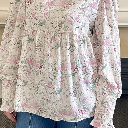 Floral blouse with long sleeves and blue jeans worn by a person.