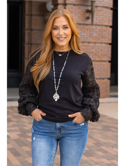 Black Lace Sleeve Top combines timeless elegance with modern charm. Featuring intricate lace sleeves and a classic crew neckline.