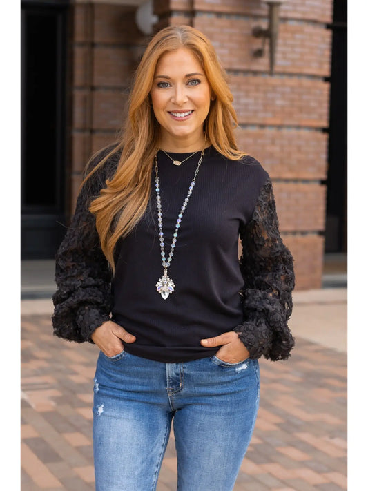 Black Lace Sleeve Top combines timeless elegance with modern charm. Featuring intricate lace sleeves and a classic crew neckline.