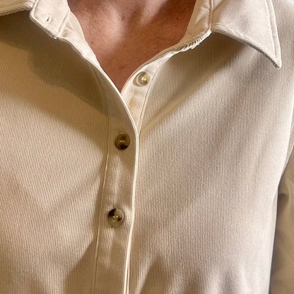 Close-up of a beige button-up shirt with a collar