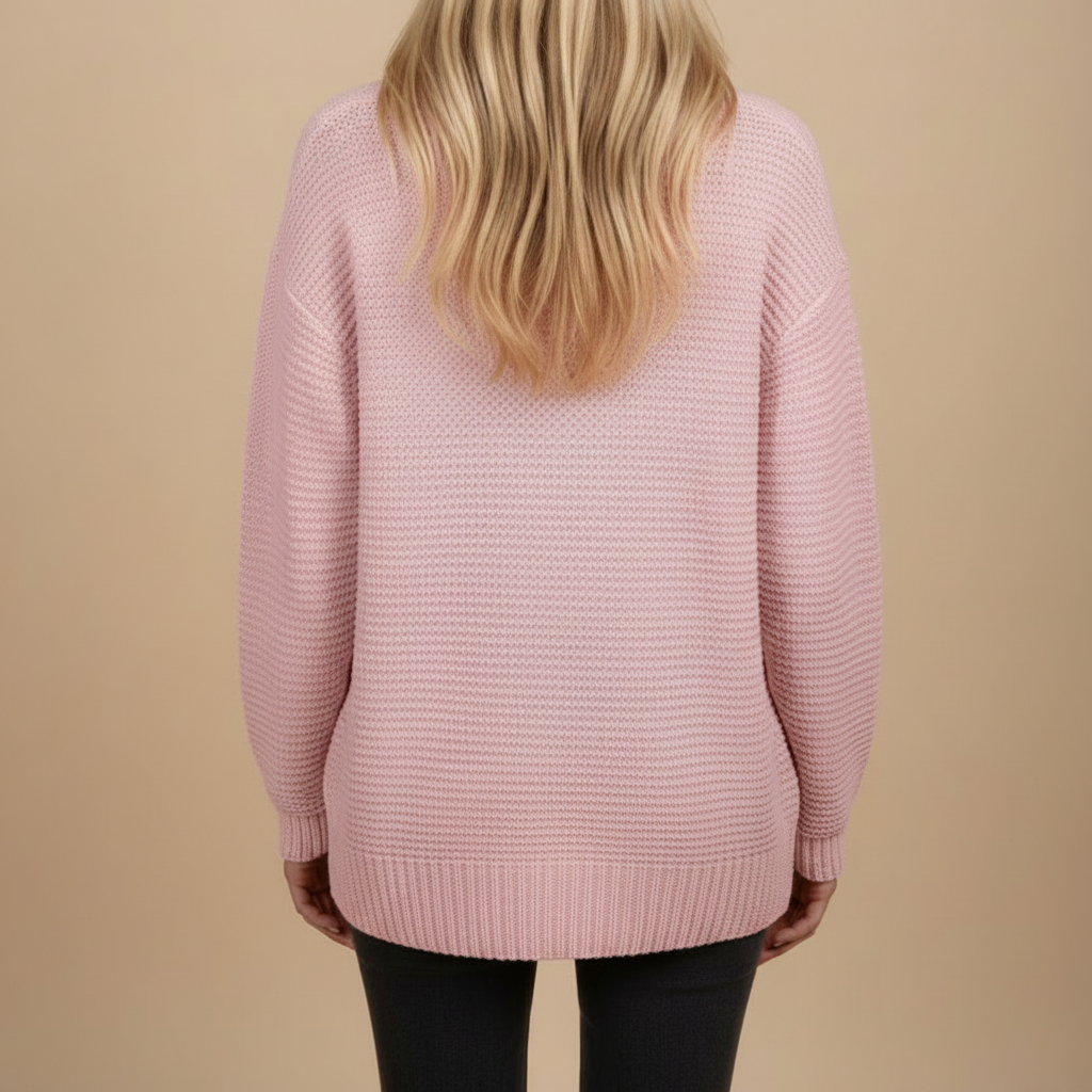 Person wearing a pink sweater against a beige background