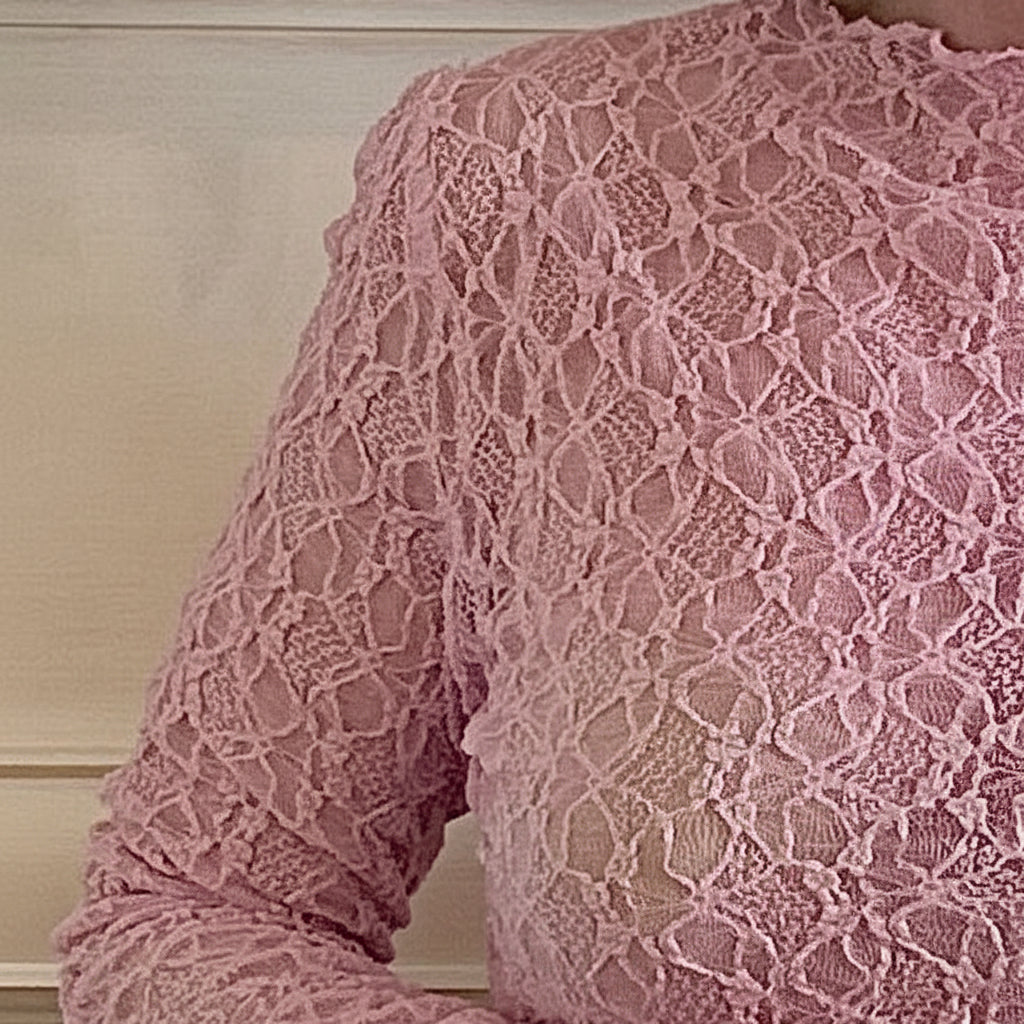Close-up of a pink lace garment against a neutral background