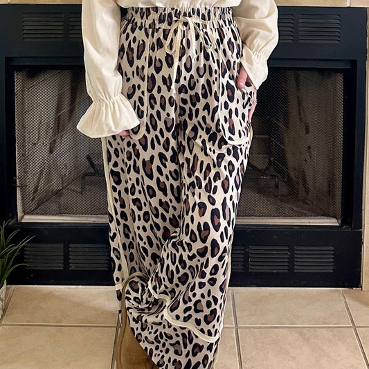 Woman standing in a living room with a fireplace and decorative mantel.