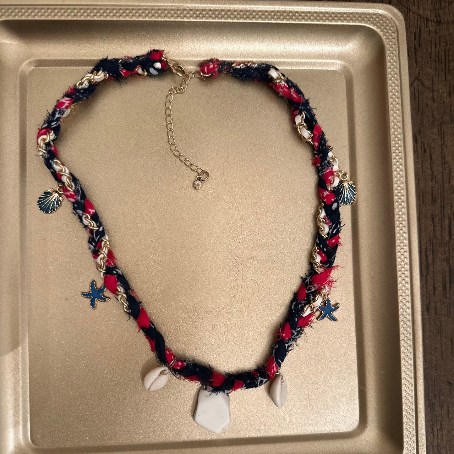 Necklace with colorful beads and charms on a beige tray