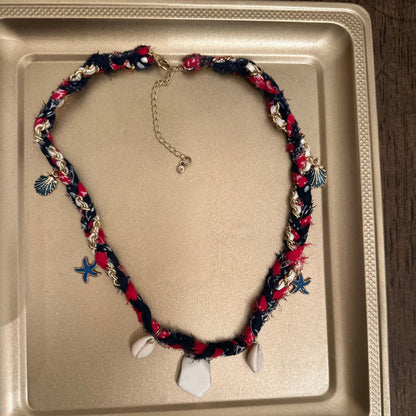 Necklace with colorful beads and charms on a beige tray