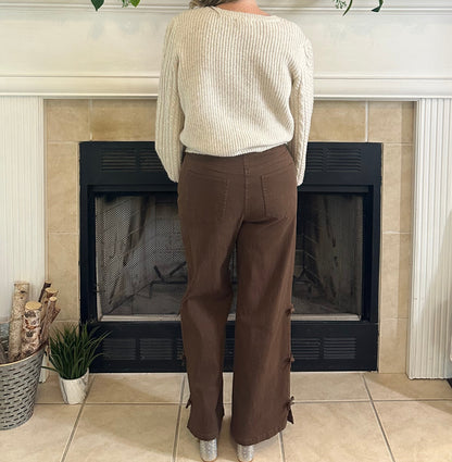 Person standing in a living room with a television, fireplace, and decorative items.