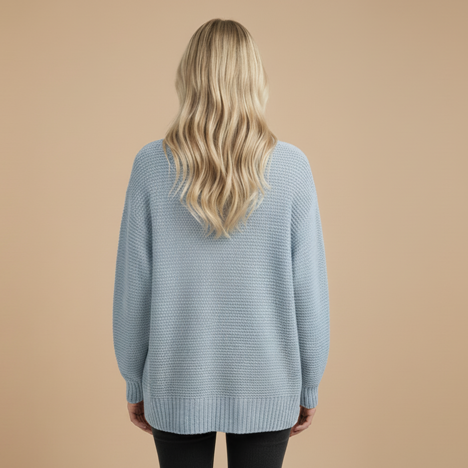 Person wearing a light blue sweater on a beige background