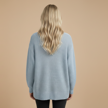 Person wearing a light blue sweater on a beige background