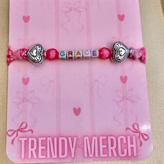 Pink bracelet with heart-shaped charms on a 'Trendy Merch' card