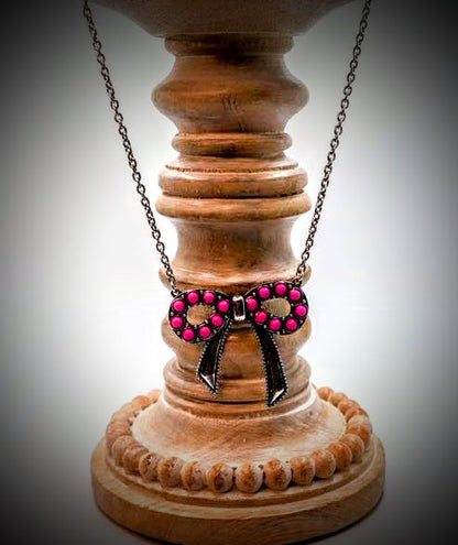 This vintage necklace features a striking bow pendant adorned with beaded accents, showcasing a beautiful vintage-inspired charm.