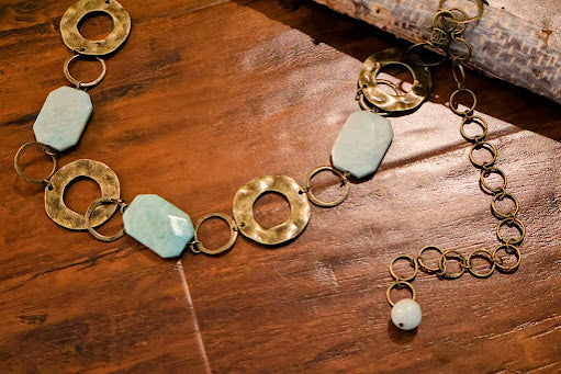 An Accent Belt. This distinctive 46-inch belt features a harmonious blend of textured metal chains and natural stones. 