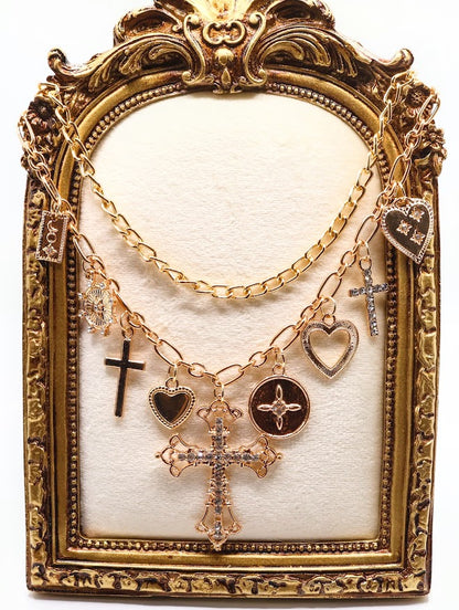 Charm Necklace. This beautifully layered gold-tone necklace features an enchanting collection of delicate charms, including graceful hearts, intricate crosses, and classic coin pendants. The centerpiece, a stunningly detailed cross.