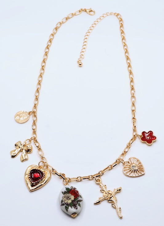  Vintage Charm Necklace. Featuring a gold-tone chain adorned with an exquisite collection of charms, including a rose-adorned heart, a dainty bow, a floral oval pendant, and a radiant cross.
