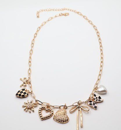  Charm Cascade Necklace  Featuring a gold-tone chain adorned with charming pendants, including textured hearts, a delicate bow, a luminous pearl, and checkered-inspired accents.
