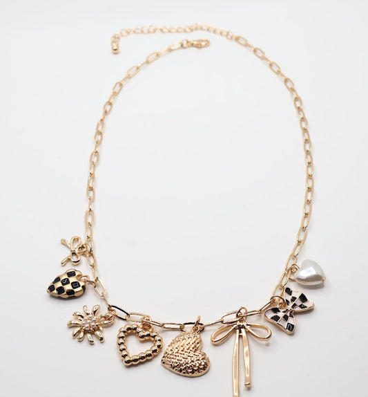  Charm Cascade Necklace  Featuring a gold-tone chain adorned with charming pendants, including textured hearts, a delicate bow, a luminous pearl, and checkered-inspired accents.