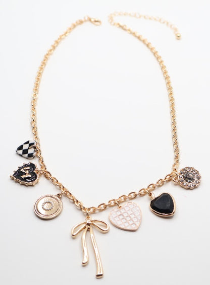  Charm Necklace is a whimsical and eye-catching accessory, perfect for adding character to any outfit. This necklace features a series of unique charms, including hearts, a bow, a sparkling gem, and intricate patterns, all beautifully arranged on a gold-tone chain.