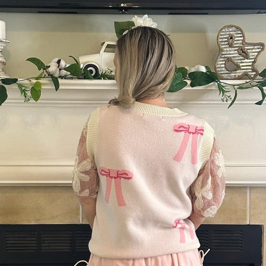 Bow Sweater Vest featuring an all-over bow design, this is a sleeveless sweater vest with a V-neckline. 