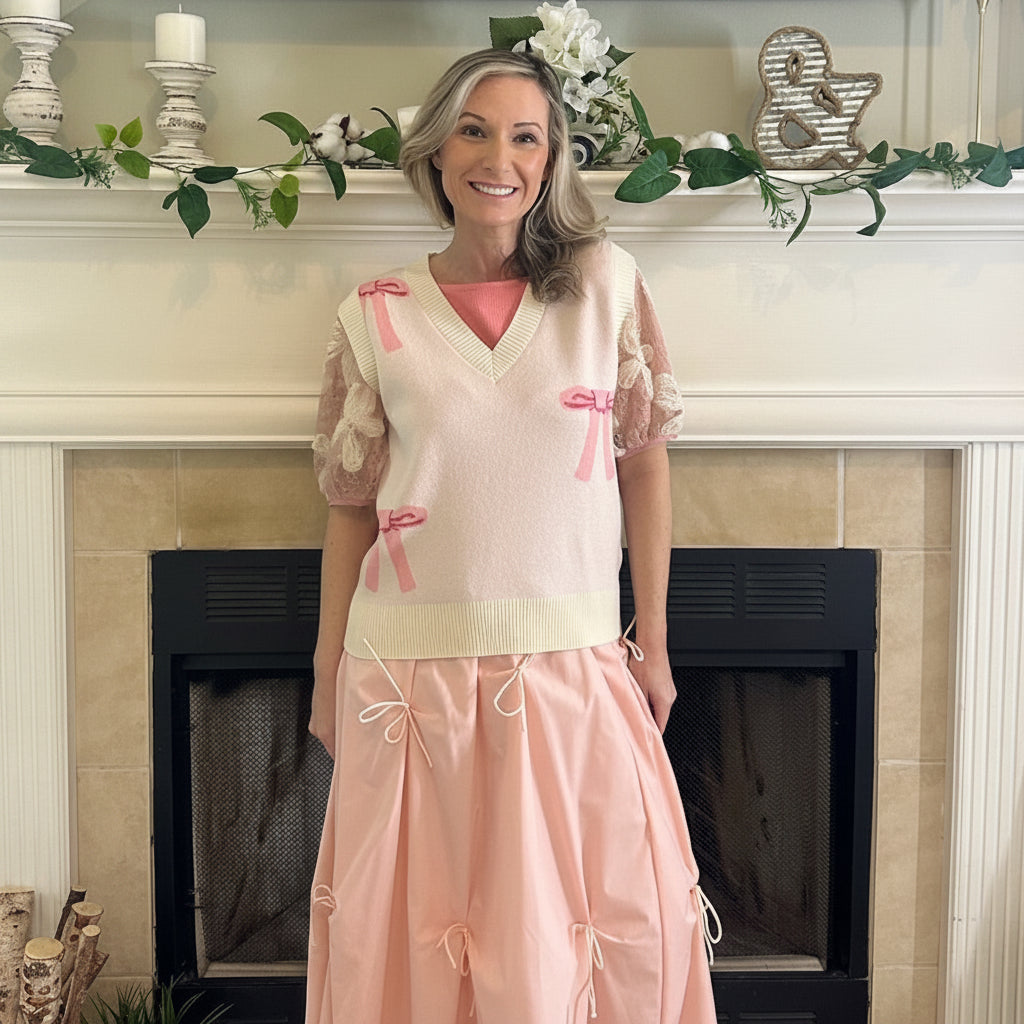 Blush Pink Bow Detail Midi Skirt is a feminine and elegant piece designed to elevate your wardrobe. This flowy midi skirt features delicate bow accents throughout.