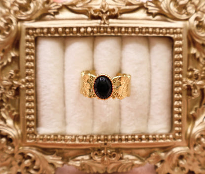  Ring is a bold yet elegant statement piece, designed for those who embrace their unique style. Featuring a striking oval black stone framed by textured gold-tone detailing.