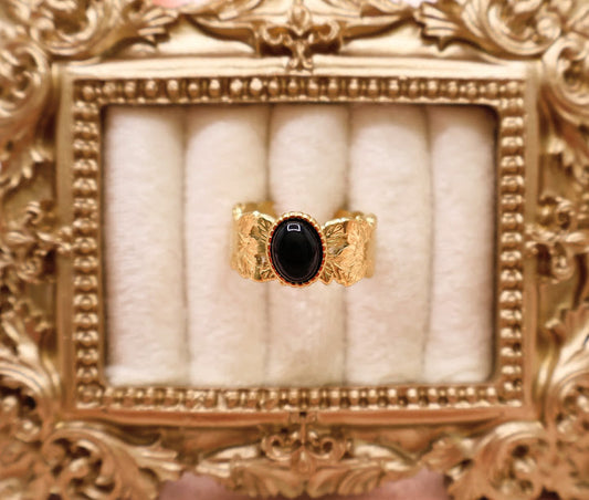  Ring is a bold yet elegant statement piece, designed for those who embrace their unique style. Featuring a striking oval black stone framed by textured gold-tone detailing.