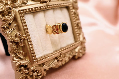  Ring is a bold yet elegant statement piece, designed for those who embrace their unique style. Featuring a striking oval black stone framed by textured gold-tone detailing.