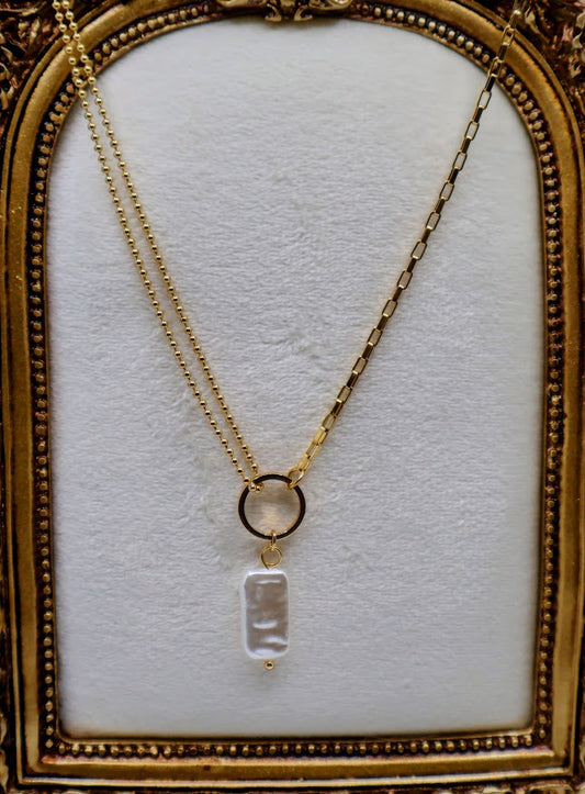  Pendant Necklace is a chic and modern accessory that embodies effortless style. Featuring a stunning rectangular pearl-like charm suspended from a sleek gold-tone ring.