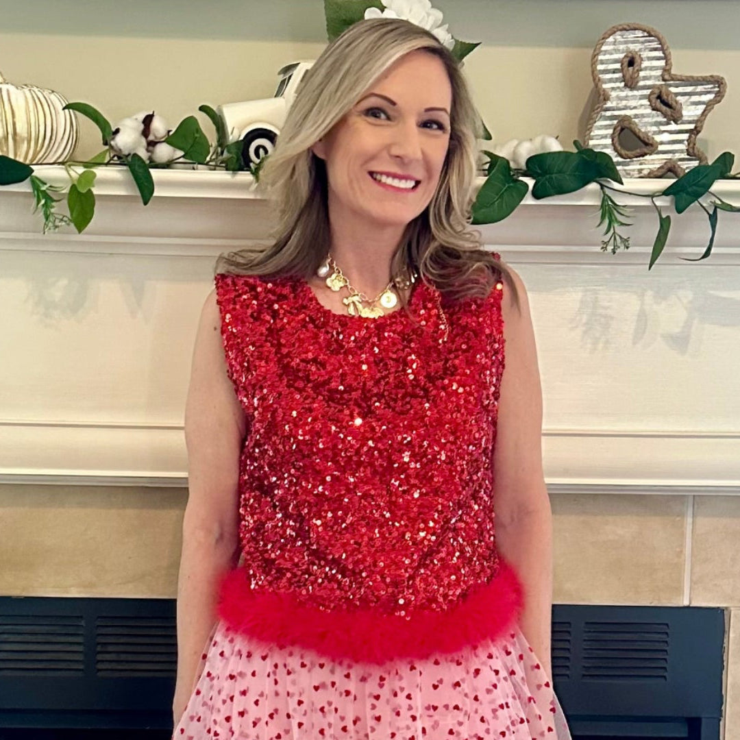 Sequin Feather Crop Top is a bold and glamorous statement piece. Featuring shimmering red sequins and a playful feathered hem.