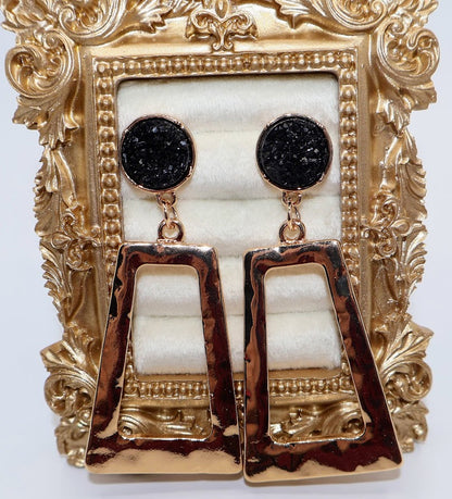 Gold and black earrings feature a unique geometric design with a hammered gold finish.