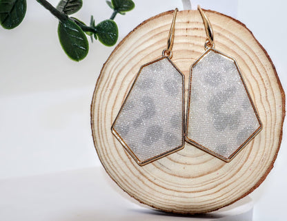 Geometric earrings featuring a chic pentagon shape framed in radiant gold, these earrings showcase a subtle leopard print design, 