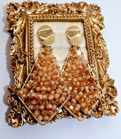 Pair of golden beaded earrings feature a sophisticated geometric design adorned with radiant golden bead.
