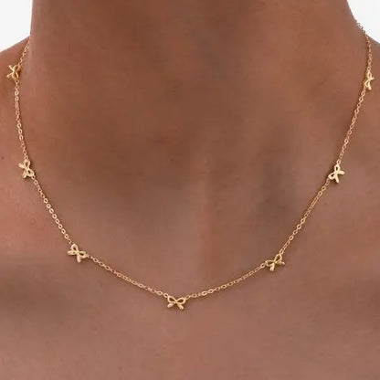  Gold Bow Charm Necklace is a delicate and timeless accessory that exudes elegance and charm. Featuring three dainty bow-shaped accents.
