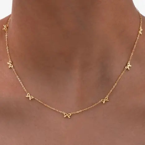  Gold Bow Charm Necklace is a delicate and timeless accessory that exudes elegance and charm. Featuring three dainty bow-shaped accents.