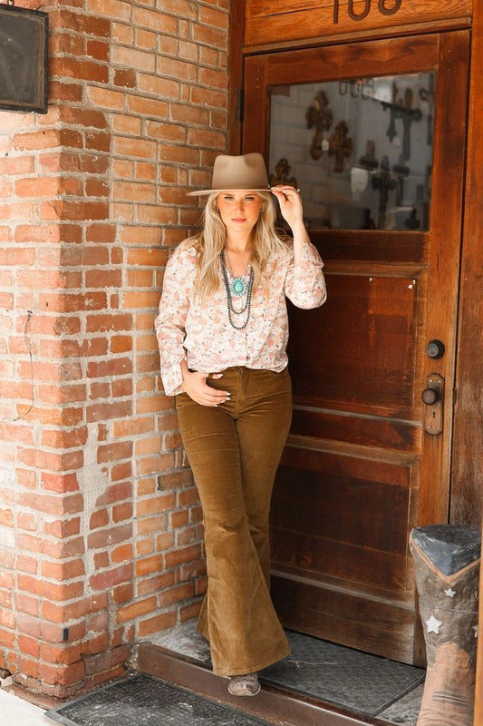  Floral Button-Up Blouse is a charming and feminine wardrobe staple. Featuring a delicate floral print, this unlined blouse offers a lightweight feel and a relaxed fit. 