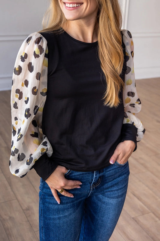 Leopard Sleeve Top is a stylish blend of simplicity and boldness. Featuring sheer leopard-print puff sleeves and a sleek solid bodice.