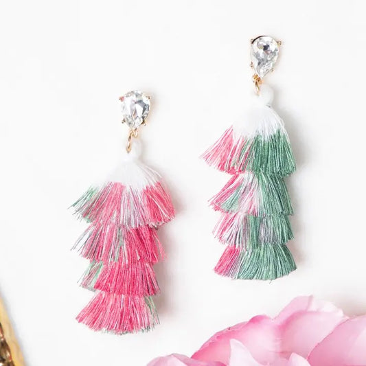 Pair of tassel earrings with pink and green layers on a white background