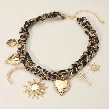 Leopard print bracelet with gold charms on a light background
