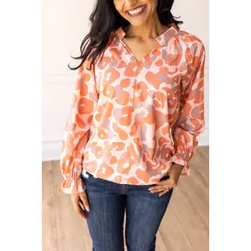 Coral Leopard Blouse. Featuring a relaxed fit, bold coral leopard print, and charming ruffle details on the cuffs.