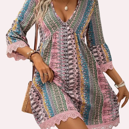 Trendy Merch Joelle Boho Lace Trim Mini Dress with V-neck, 3/4 bell sleeves, and colorful print. 100% Polyester.