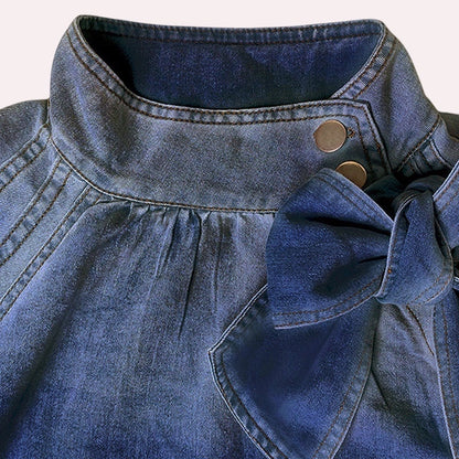 Trendy Merch Campbell Puff Sleeve Denim Blouse with bow detail and high neckline in blue cotton-polyester blend.